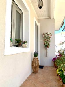 a porch with a vase of flowers and a window at Leo's city apartment in Lefkada