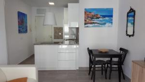 a kitchen with a small table and chairs in a room at Malagueta & Port in Málaga