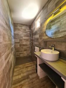 ein Bad mit einem Waschbecken und einem Spiegel in der Unterkunft Les Buisses en Provence in Piolenc