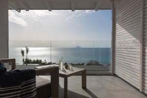 a patio with a table and a view of the ocean at Midenza Seaside & Nature Retreat in Capo Vaticano