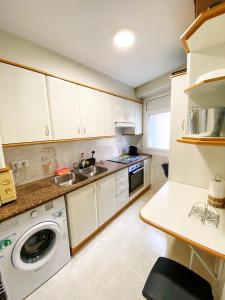 eine Küche mit einer Spüle und einer Waschmaschine in der Unterkunft Apartamento el Cau, acogedor y cerca del Montseny in Arbúcies