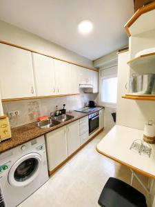 a kitchen with a sink and a washing machine at Apartamento el Cau, acogedor y cerca del Montseny in Arbúcies