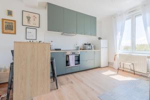 een keuken met blauwe kasten en een witte koelkast bij Chez Côme in Metz +14 foto's