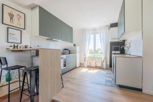 een keuken met groene kasten en een aanrecht bij Chez Côme in Metz