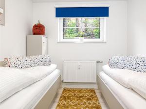 two beds in a room with a window at Souterrain Wohnung Seegras in Insel Poel