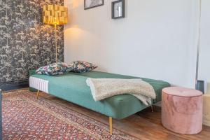 een woonkamer met een groene bank en een roze kruk bij Chez Côme in Metz