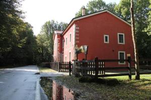 een rood gebouw met een hek naast een straat bij Cantoniera D'Umbra Agriturismo in Vico del Gargano