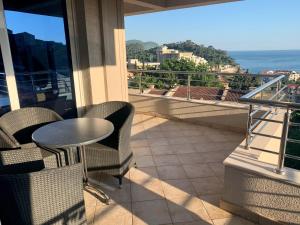 Un balcón con mesa y sillas y vista al mar. en Blue Sky Apartment, en Petrovac na Moru