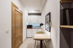 una pequeña cocina con mesa y puerta en Chamberí Suites en Madrid