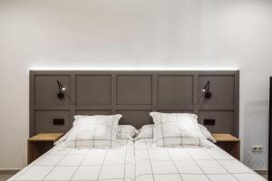 A bed or beds in a room at Exclusive Rooms in the Heart of the City