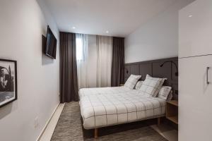 A bed or beds in a room at Exclusive Rooms in the Heart of the City