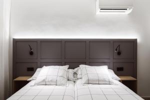 A bed or beds in a room at Exclusive Rooms in the Heart of the City