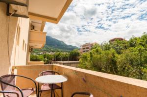 a table and chairs on a balcony with a view at Apartmani Lasta in Dobra Voda