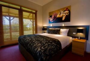 a bedroom with a large bed and a painting on the wall at Forrester Court Cliff Top Cottages in Cascade