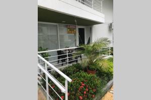 a white railing in front of a building with flowers at HERMOSO APARTA ESTUDIO en Melgar in Melgar