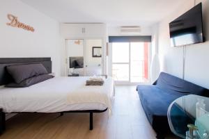 una camera con un grande letto e un divano blu di Dream Studio in Benalmadena Costa del Sol a Benalmádena