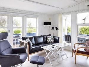 sala de estar con sofá negro y mesa en 6 person holiday home in Slagelse, en Slagelse