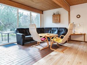 a living room with a couch and a table and chairs at 6 person holiday home in Thisted in Klitmøller