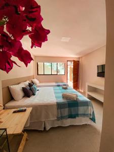 a bedroom with a large bed with red flowers on the wall at Pousada Praiana in Porto De Galinhas