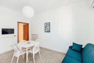 a living room with a table and a blue couch at In Centro Residenza - Suites & Apartments in Vasto