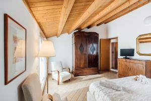 a bedroom with a bed and a chair and a television at In Centro Residenza - Suites & Apartments in Vasto