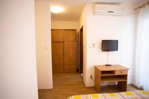 una camera da letto con un letto e una TV a parete di Bol Studio Gospojica a Bol