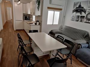kuchnia i salon ze stołem i krzesłami w obiekcie APARTAMENTO LEVIES w Sewilli