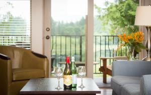 two bottles and glasses on a table in a living room at The Cottages on Salt Spring Island in Ganges