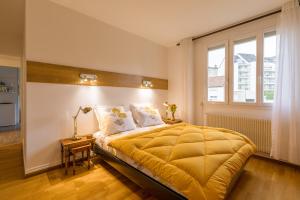 Un dormitorio con una cama grande y una ventana en Appartement Climatisé 100M2 7mn Centre Ville Garage 5Pièces 5 Adultes Bébé Arrivée Autonome, en Dijon