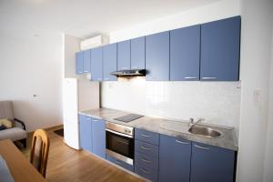 una cucina con mobili blu e un lavandino di Bol apartments Gospojica a Bol
