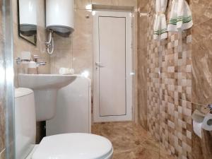 a bathroom with a toilet and a sink at Megi Luxury Apartments in Pomorie