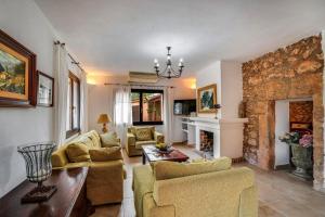 a living room with couches and a stone fireplace at Finca Can Moleta in Cala Mendia