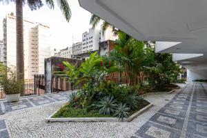 een binnenplaats met bomen en planten in een gebouw bij Apart Super Estiloso Copa Leme in Rio de Janeiro