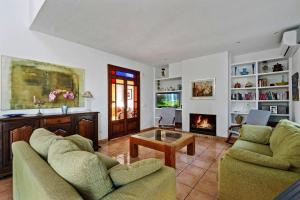 a living room with two couches and a fireplace at Finca Vista Alegre in Cala Mendia