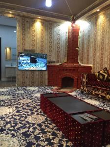 a living room with a fireplace and a tv at شاليه ابها ون in Al ‘Az̧āz̧ah