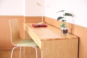 a wooden desk with a plant on top of it at ケイアイコンホテルズ 新栄901 in Nagoya