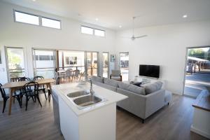 a kitchen and living room with a couch and a table at Crab Cottages in Urangan