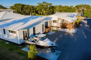 una vista aérea de un barco estacionado frente a una casa en Crab Cottages, en Urangan