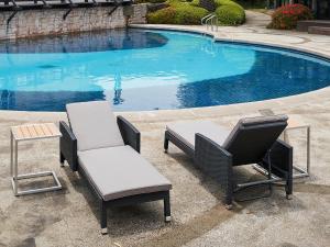 two chairs and a table next to a swimming pool at Bloom Hotel in Seogwipo