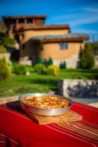 un tazón de comida en una mesa frente a una casa en Eco Village Under the Cliffs, en Ilindentsi