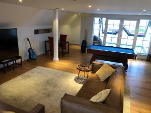 a living room with a couch and a pool table at Stunning Penthouse with Sea Views - Close to the Beach, Sea & Bars ,Restaurants & Shops in Leigh-on-Sea
