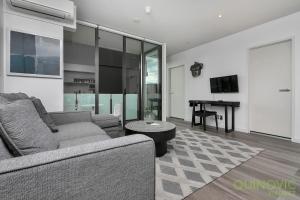- un salon avec un canapé et une table dans l'établissement QV Modern Design 1 Bedroom Apt with Wifi - 856, à Auckland