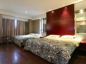 a hotel room with two beds and a large headboard at Nanjing Kaibin Apartment -Xin Jie Kou in Nanjing