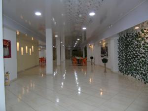 a large lobby with a white tile floor and a wall with plants at Hotel Paradise del Cafe in Pereira