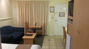 a hotel room with a blue couch and a table at Dalby Mid Town Motor Inn in Dalby