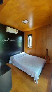 Casa da Árvore espaço Vila da Serra في نوفا ليما: غرفة نوم بسرير كبير في غرفة