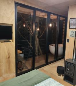 Habitación con ventana, bañera y TV. en Casa da Árvore espaço Vila da Serra, en Nova Lima