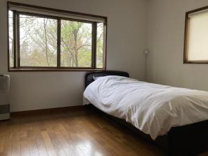 Un pat sau paturi într-o cameră la Yatsugatake Cottage