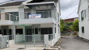 un edificio blanco con una puerta delante en WeJDAN INN BALIK PULAU, PENANG ISLAND, en Balik Pulau