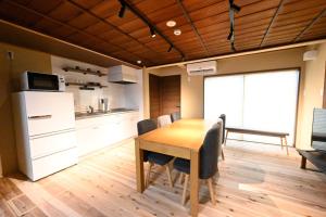 cocina y comedor con mesa y sillas en Manabi-stay Matsue 駅近伊勢宮町どこに行くにも最高に便利な古民家一棟貸切ホテル, en Matsue